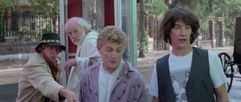 Movie still from “Bill & Ted's Excellent Adventure” (1989), directed by Stephen Herek – A group of people standing next to each other on the street; Medium shot, Over the shoulder angle