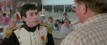 Movie still from “Bill & Ted's Excellent Adventure” (1989), directed by Stephen Herek – A man in a military uniform is holding something in his mouth; Close Up shot, Over the shoulder angle