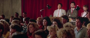 Movie still from “Bill & Ted's Excellent Adventure” (1989), directed by Stephen Herek – A crowd of people sitting and standing in front of a microphone; Medium shot, High angle