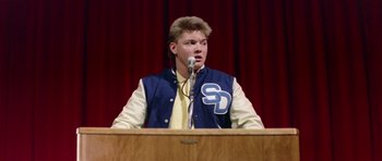 Movie still from “Bill & Ted's Excellent Adventure” (1989), directed by Stephen Herek – A young man is speaking at a podium in front of an audience; Close Up shot, Low angle