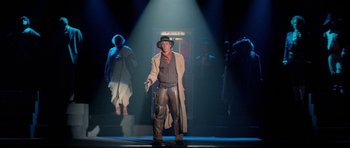 Movie still from “Bill & Ted's Excellent Adventure” (1989), directed by Stephen Herek – A man dressed as a cowboy standing on a stage; Wide shot, Low angle