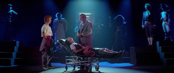 Movie still from “Bill & Ted's Excellent Adventure” (1989), directed by Stephen Herek – A man standing next to a woman laying on top of a bed; Wide shot, Over the shoulder angle