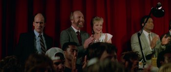 Movie still from “Bill & Ted's Excellent Adventure” (1989), directed by Stephen Herek – A man and a woman standing next to each other in front of a crowd; Medium shot, Over the shoulder angle