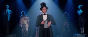 Movie still from “Bill & Ted's Excellent Adventure” (1989), directed by Stephen Herek – A man wearing a top hat and a suit and tie; Medium shot, Low angle