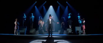 Movie still from “Bill & Ted's Excellent Adventure” (1989), directed by Stephen Herek – A man wearing a top hat and a suit standing in front of a crowd; Wide shot, Low angle