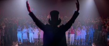 Movie still from “Bill & Ted's Excellent Adventure” (1989), directed by Stephen Herek – A man in a top hat is in front of a group of people; Wide shot, Low angle