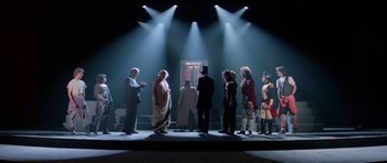 Movie still from “Bill & Ted's Excellent Adventure” (1989), directed by Stephen Herek – A group of people standing on a stage under lights; Wide shot, Low angle