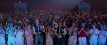 Movie still from “Bill & Ted's Excellent Adventure” (1989), directed by Stephen Herek – A group of people standing in front of an audience; Wide shot, High angle