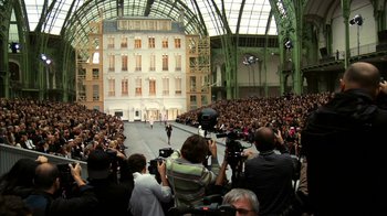 A group of people taking pictures of a fashion show