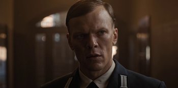 Movie still from “Dark” (2017), created by Baran bo Odar – A person wearing a uniform; Close Up shot, Low angle