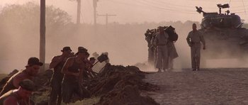 Movie still from “Biloxi Blues” (1988), directed by Mike Nichols – A group of people walking down a dirt road; Wide shot, High angle