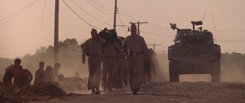 Movie still from “Biloxi Blues” (1988), directed by Mike Nichols – A group of men walking down a dirt road; Wide shot, Low angle