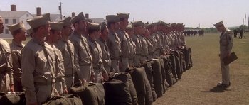 Movie still from “Biloxi Blues” (1988), directed by Mike Nichols – A group of men standing next to each other in uniform; Wide shot, Low angle