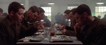 Movie still from “Biloxi Blues” (1988), directed by Mike Nichols – A group of men sitting at a table eating food; Wide shot, Low angle
