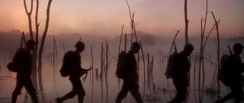 Movie still from “Biloxi Blues” (1988), directed by Mike Nichols – A group of soldiers walking across a body of water; Wide shot, Low angle