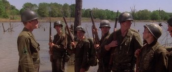 Movie still from “Biloxi Blues” (1988), directed by Mike Nichols – A group of soldiers standing next to each other holding guns; Medium shot, Low angle