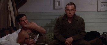 Movie still from “Biloxi Blues” (1988), directed by Mike Nichols – Two men sitting next to each other on a bench; Medium shot, High angle