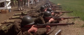 Movie still from “Biloxi Blues” (1988), directed by Mike Nichols – A group of men in military fatigues and helmets are holding rifles; Wide shot, Low angle