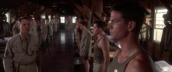 Movie still from “Biloxi Blues” (1988), directed by Mike Nichols – A group of men standing next to each other in a room; Wide shot, Low angle