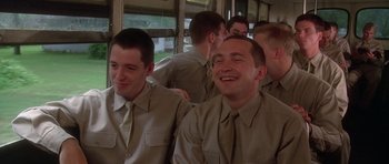 Movie still from “Biloxi Blues” (1988), directed by Mike Nichols – A group of young men sitting next to each other on a bus; Medium shot, Low angle