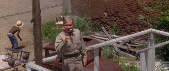 Movie still from “Biloxi Blues” (1988), directed by Mike Nichols – A man in a military uniform is holding a toothbrush; Medium shot, High angle