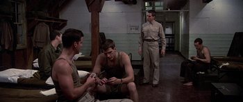 Movie still from “Biloxi Blues” (1988), directed by Mike Nichols – A group of men sitting on the ground in a room; Wide shot, Over the shoulder angle