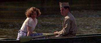 Movie still from “Biloxi Blues” (1988), directed by Mike Nichols – A man and a woman sitting in a boat on a river; Medium shot, High angle