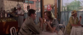 Movie still from “Biloxi Blues” (1988), directed by Mike Nichols – A man and a woman sitting at a table; Medium shot, Over the shoulder angle