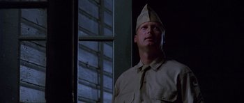Movie still from “Biloxi Blues” (1988), directed by Mike Nichols – A man wearing a hat standing in front of a window; Close Up shot, Low angle