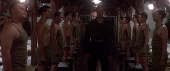 Movie still from “Biloxi Blues” (1988), directed by Mike Nichols – A group of men standing next to each other in a room; Wide shot, Low angle