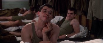 Movie still from “Biloxi Blues” (1988), directed by Mike Nichols – A man with glasses is sitting next to another man; Close Up shot, Over the shoulder angle