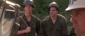 Movie still from “Biloxi Blues” (1988), directed by Mike Nichols – A couple of men standing next to each other wearing helmets; Medium shot, Low angle