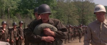 Movie still from “Biloxi Blues” (1988), directed by Mike Nichols – A group of men in military fatigues and helmets; Medium shot, Over the shoulder angle