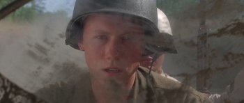 Movie still from “Biloxi Blues” (1988), directed by Mike Nichols – A man wearing a helmet talking on a cell phone; Close Up shot, Low angle