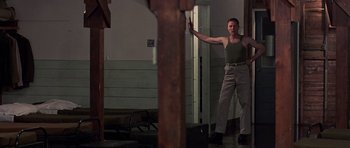 Movie still from “Biloxi Blues” (1988), directed by Mike Nichols – A man standing in front of an open door in a room; Wide shot, Low angle