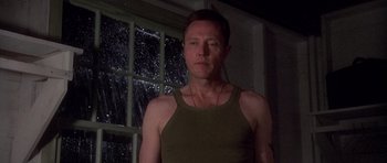 Movie still from “Biloxi Blues” (1988), directed by Mike Nichols – A man standing in front of a window at night; Medium shot, Low angle