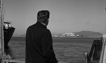 Movie still from “Birdman of Alcatraz” (1962), directed by John Frankenheimer – A man looking out over the water at a resort; Medium shot, Low angle