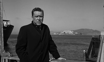 Movie still from “Birdman of Alcatraz” (1962), directed by John Frankenheimer – Black and white photograph of a man standing in front of a body of water; Medium shot, Low angle