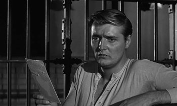 Movie still from “Birdman of Alcatraz” (1962), directed by John Frankenheimer – A black and white photo of a man holding a piece of paper; Close Up shot, Over the shoulder angle