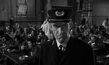 Movie still from “Birdman of Alcatraz” (1962), directed by John Frankenheimer – A man in a military uniform is standing in front of a group of people; Close Up shot, Low angle