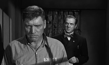 Movie still from “Birdman of Alcatraz” (1962), directed by John Frankenheimer – Two men standing next to each other in front of a window; Medium shot, Low angle