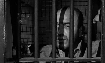 Movie still from “Birdman of Alcatraz” (1962), directed by John Frankenheimer – A black and white photo of a man behind bars; Medium shot, Low angle