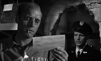 Movie still from “Birdman of Alcatraz” (1962), directed by John Frankenheimer – A man holding a piece of paper next to a man in uniform; Close Up shot, Low angle