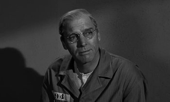 Movie still from “Birdman of Alcatraz” (1962), directed by John Frankenheimer – An older man wearing glasses and a prison uniform; Close Up shot, Over the shoulder angle