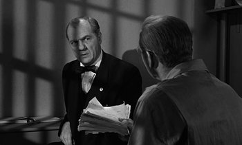 Movie still from “Birdman of Alcatraz” (1962), directed by John Frankenheimer – An older man in a suit and tie looking at another older man in a suit and tie; Medium shot, Over the shoulder angle