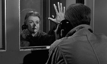 Movie still from “Birdman of Alcatraz” (1962), directed by John Frankenheimer – A woman in front of a bathroom mirror with her hand up in front of her face; Close Up shot, Over the shoulder angle