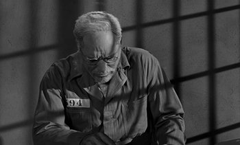 Movie still from “Birdman of Alcatraz” (1962), directed by John Frankenheimer – An old man with glasses is looking down; Close Up shot, High angle