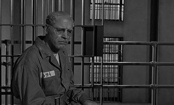Movie still from “Birdman of Alcatraz” (1962), directed by John Frankenheimer – An old man sitting in a jail cell; Medium shot, Low angle
