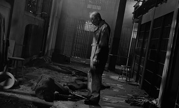 Movie still from “Birdman of Alcatraz” (1962), directed by John Frankenheimer – An old man standing in front of a dead body in an alley; Wide shot, High angle