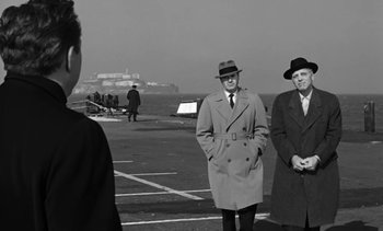 Movie still from “Birdman of Alcatraz” (1962), directed by John Frankenheimer – A black and white photo of two men standing on a pier; Medium shot, Over the shoulder angle